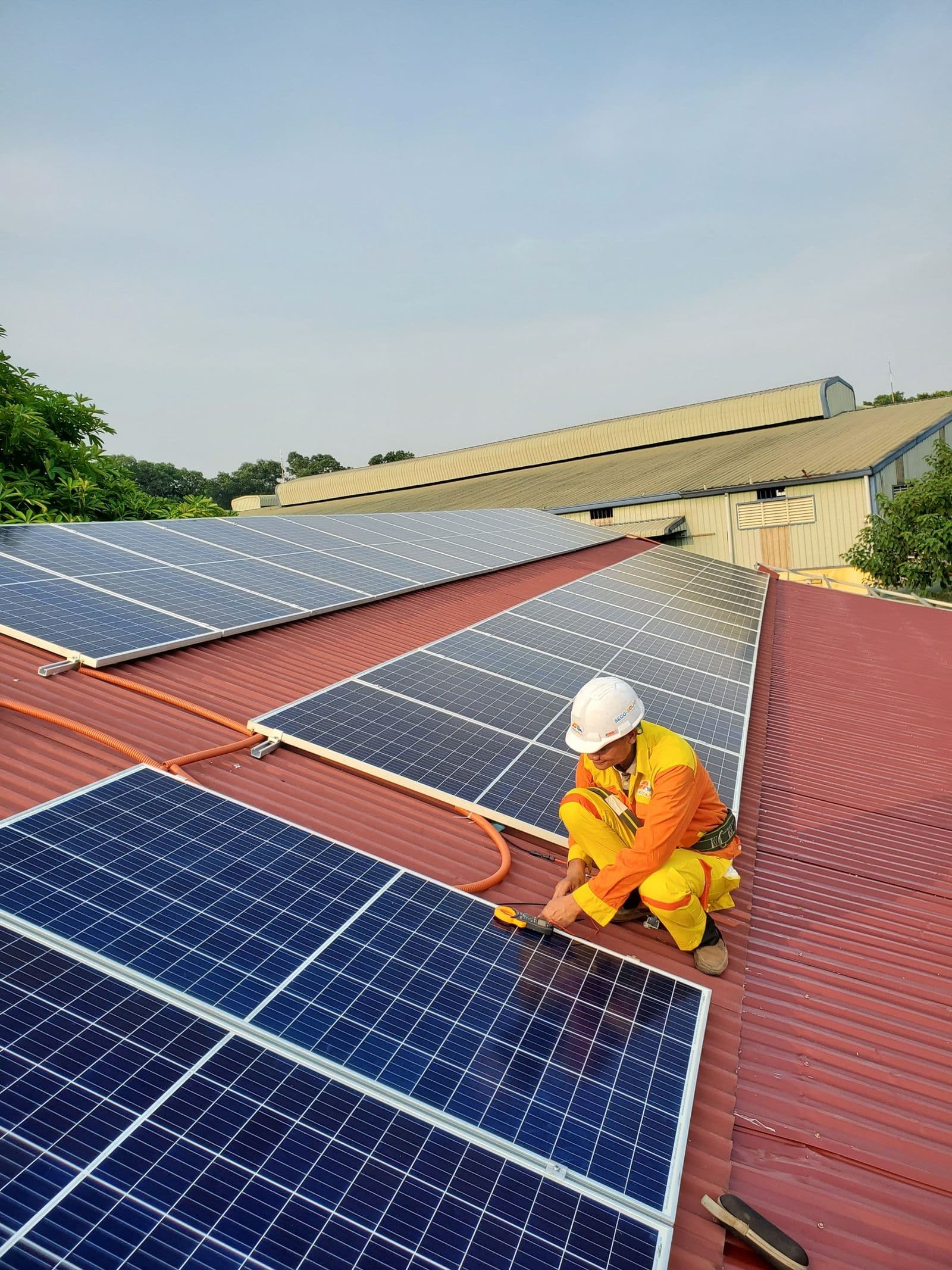 A solar professional installing panels on a rooftop